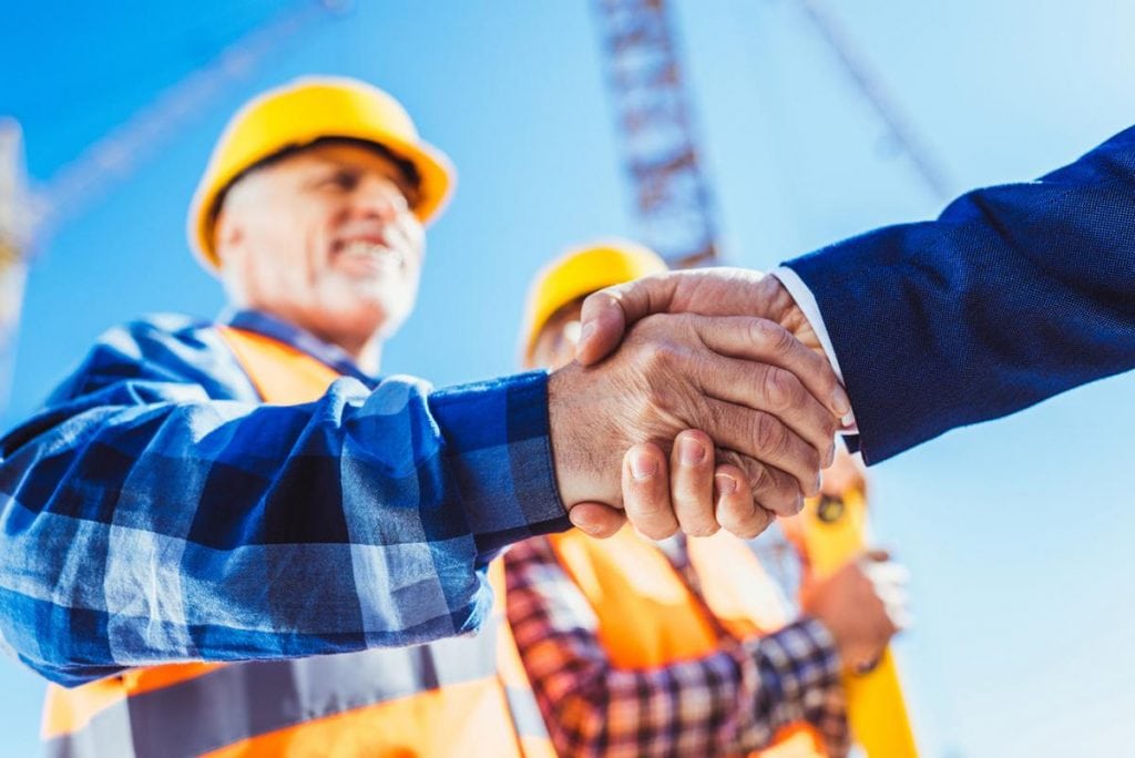 Builder and businessman shaking hands