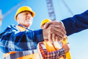 Builder and businessman shaking hands