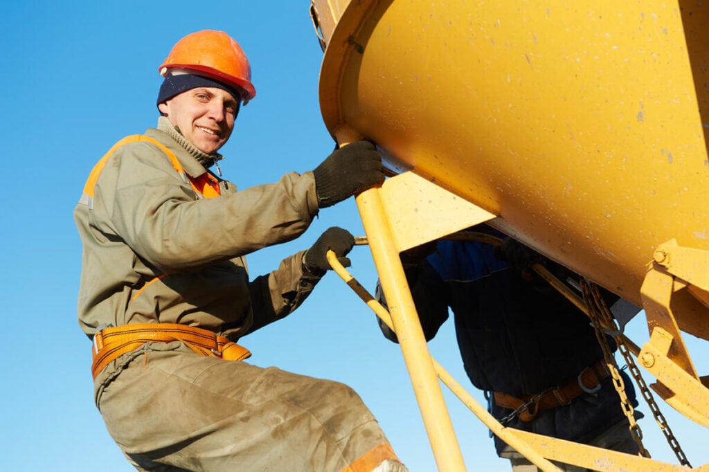 building workers pouring concrete with barrel