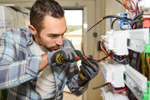 electrician working on switchboard of house building construction site